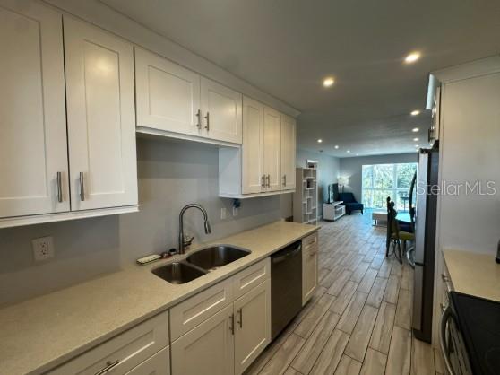 708 South Tamiami Trail, Unit 318 Venice, FL 34285 - Photo 5 of 13 a kitchen with kitchen island a sink stove and cabinets