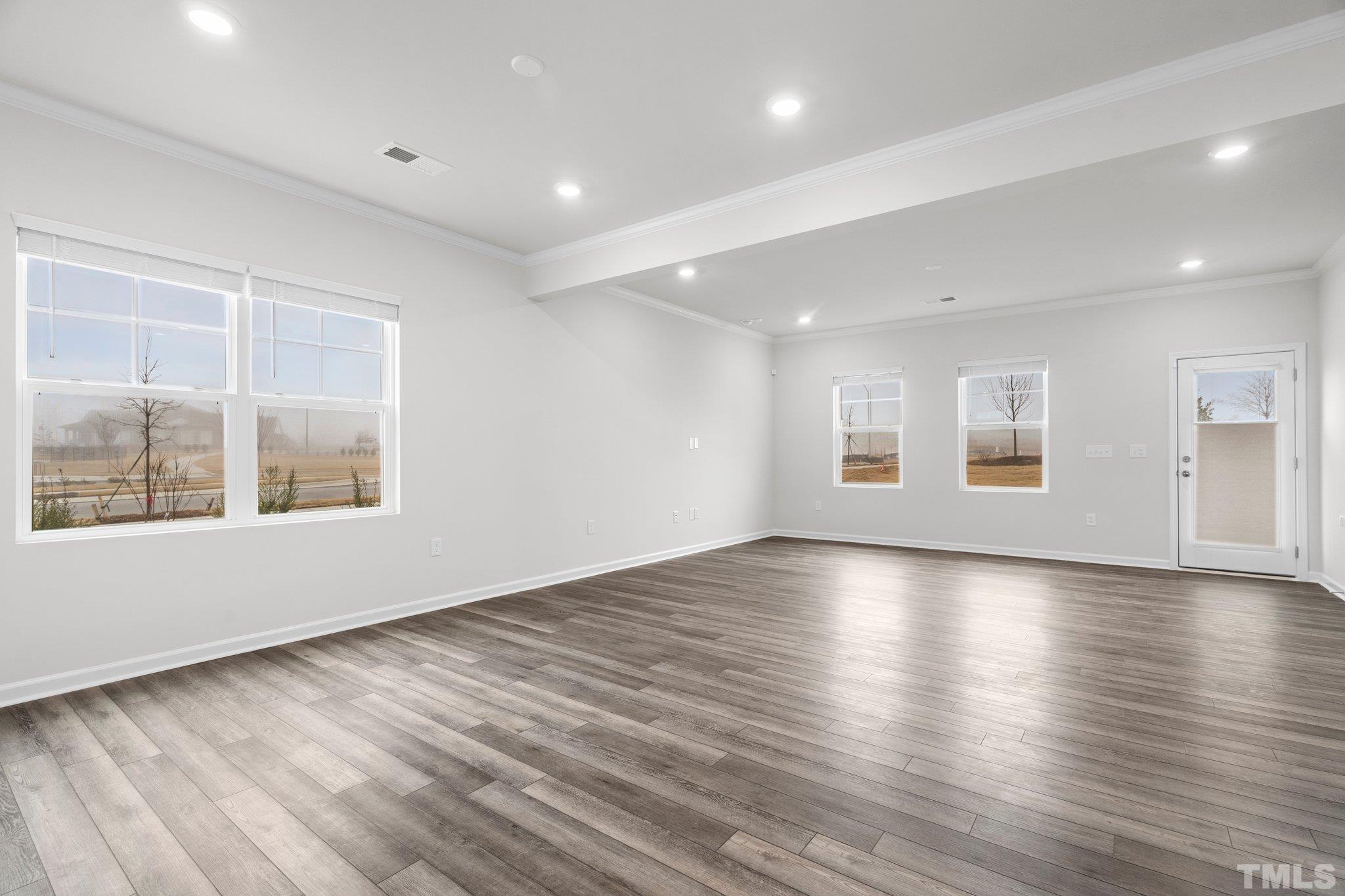 5060 Tura Street Raleigh, NC 27610 - Photo 16 of 50 a view of an empty room with wooden floor and a window