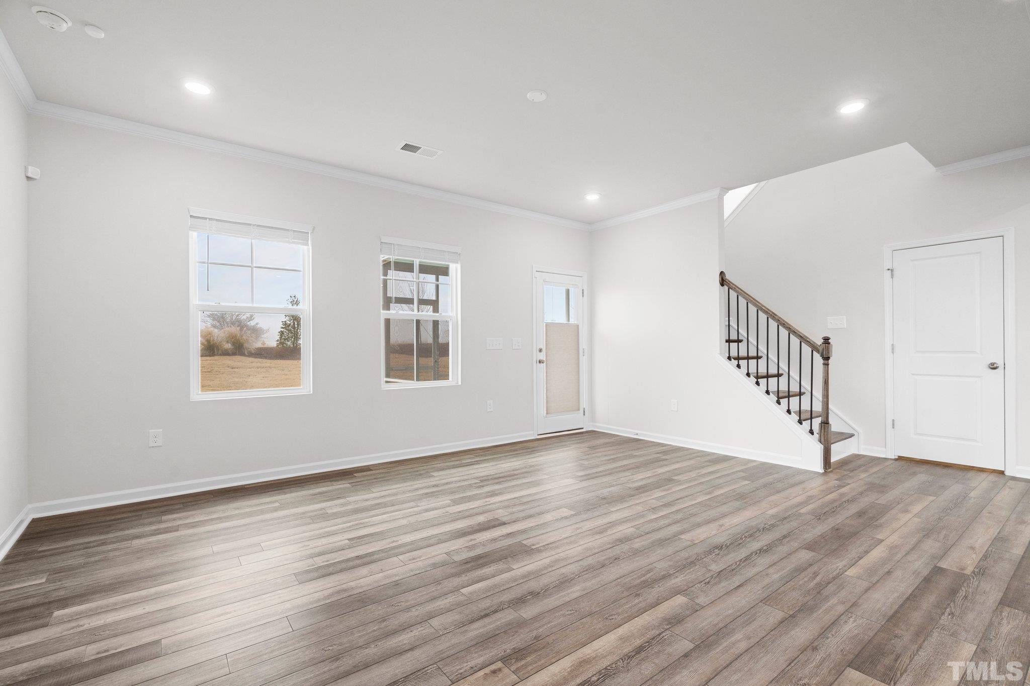 5060 Tura Street Raleigh, NC 27610 - Photo 17 of 50 a view of an empty room with wooden floor and a window