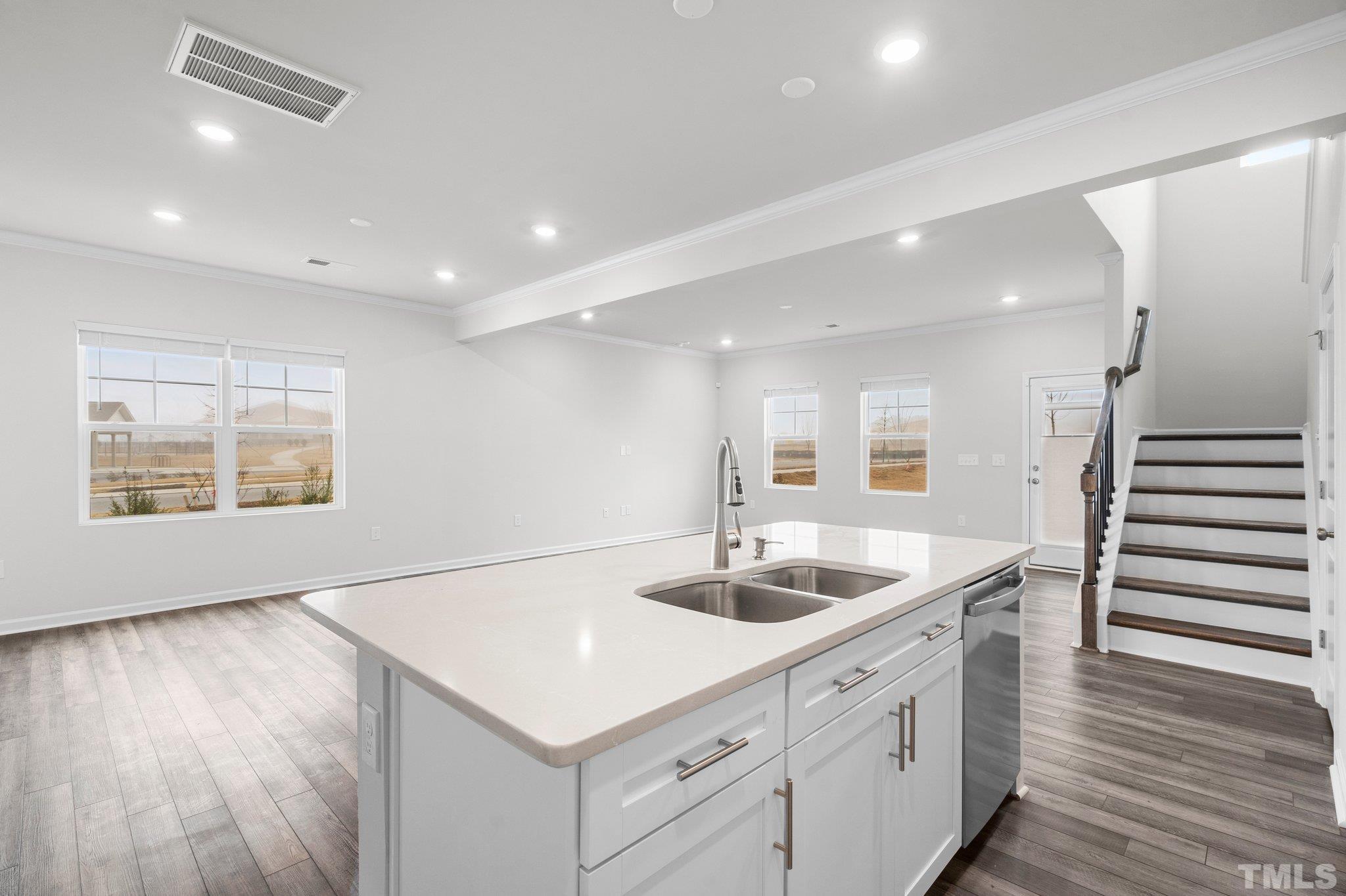 5060 Tura Street Raleigh, NC 27610 - Photo 21 of 50 a kitchen with a sink stainless steel appliances and wooden floor