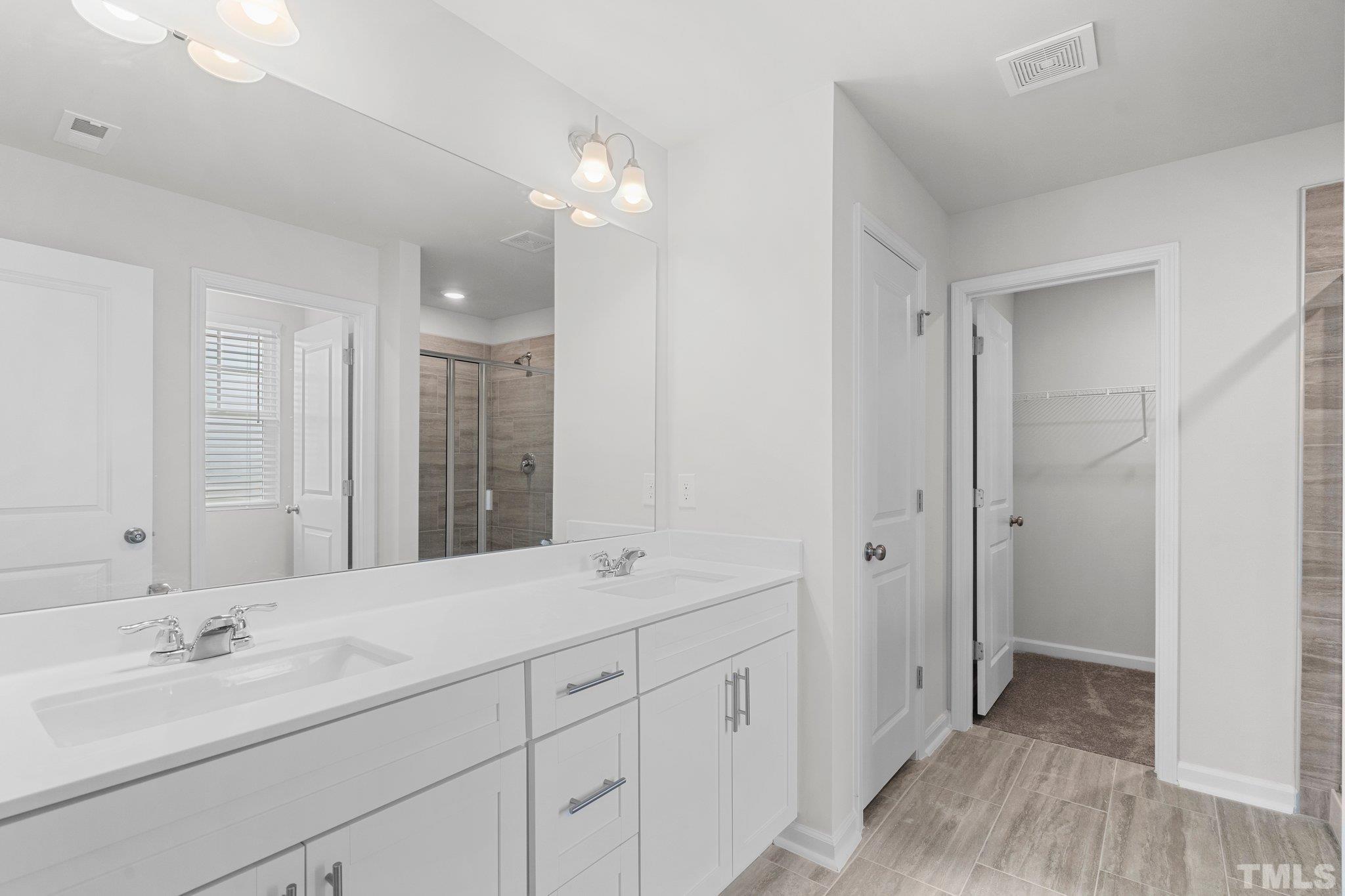 5060 Tura Street Raleigh, NC 27610 - Photo 27 of 50 a bathroom with double sink and three mirror