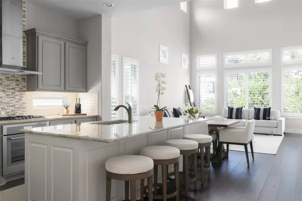 a large kitchen with kitchen island a dining table chairs and a sink