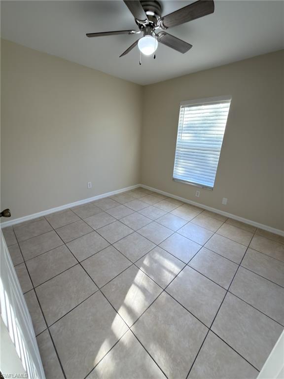 2513 48th Street Southwest Lehigh Acres, FL 33976 - Photo 8 of 22 an empty room with windows and ceiling fan
