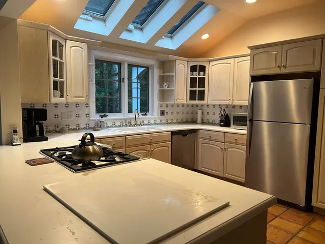 a kitchen with granite countertop a sink stainless steel appliances and cabinets