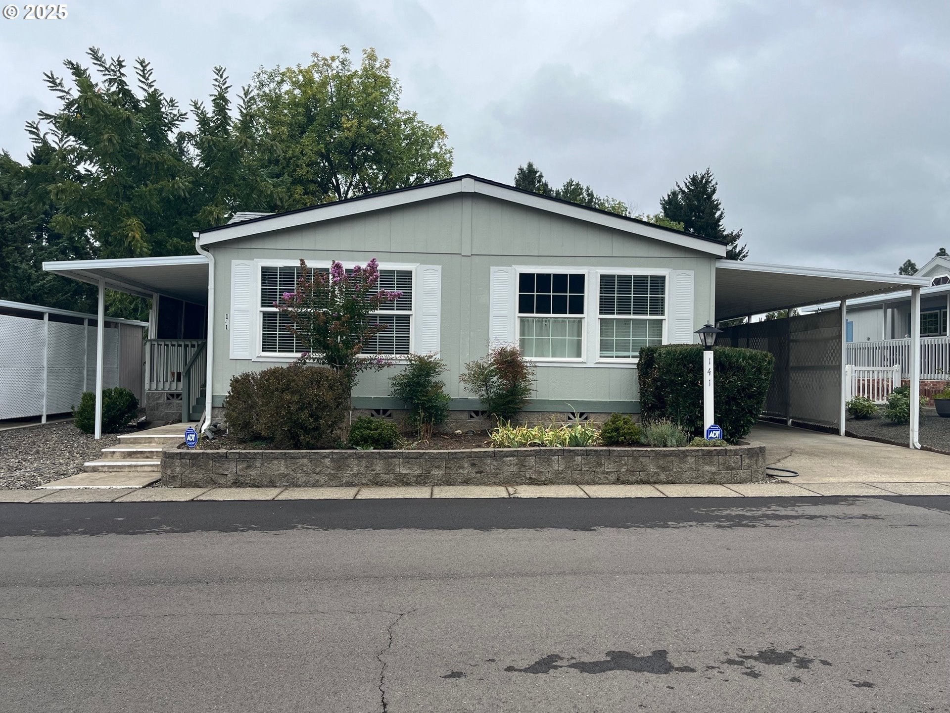 a front view of a house with a yard and potted plants