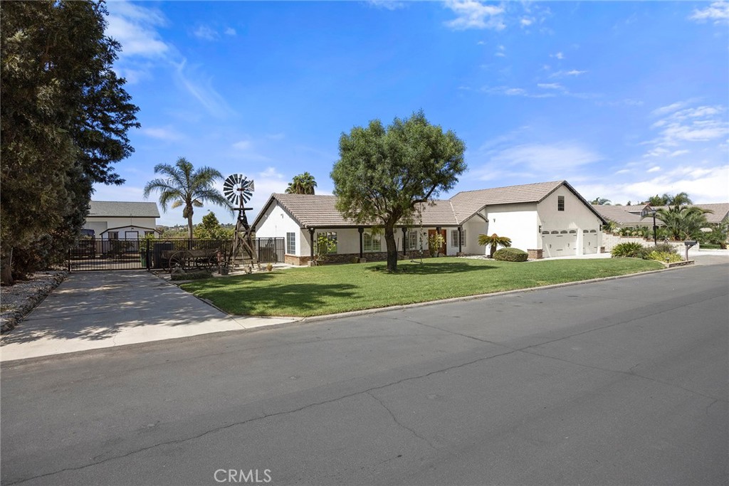 A lush front lawn, mature plantings, and side driveway frame the home