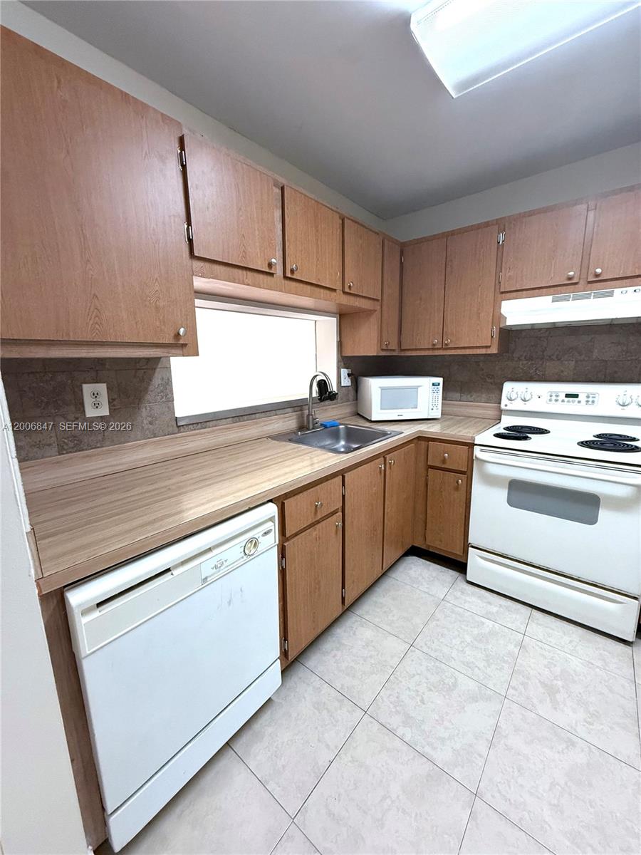 10835 Southwest 112th Avenue, Unit 306 Miami, FL 33176 - Photo 11 of 19 a kitchen with a stove sink and cabinets
