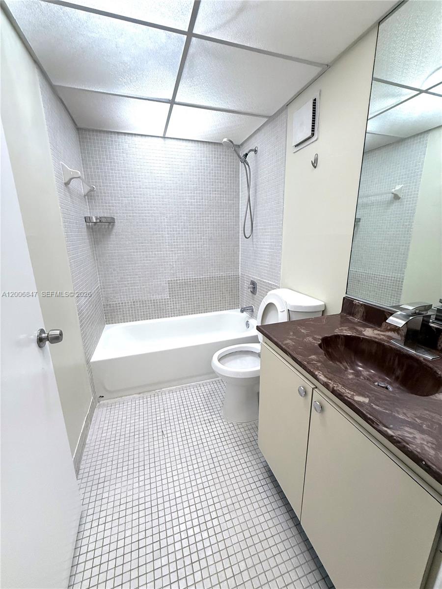 10835 Southwest 112th Avenue, Unit 306 Miami, FL 33176 - Photo 18 of 19 a bathroom with a granite countertop sink a toilet and shower