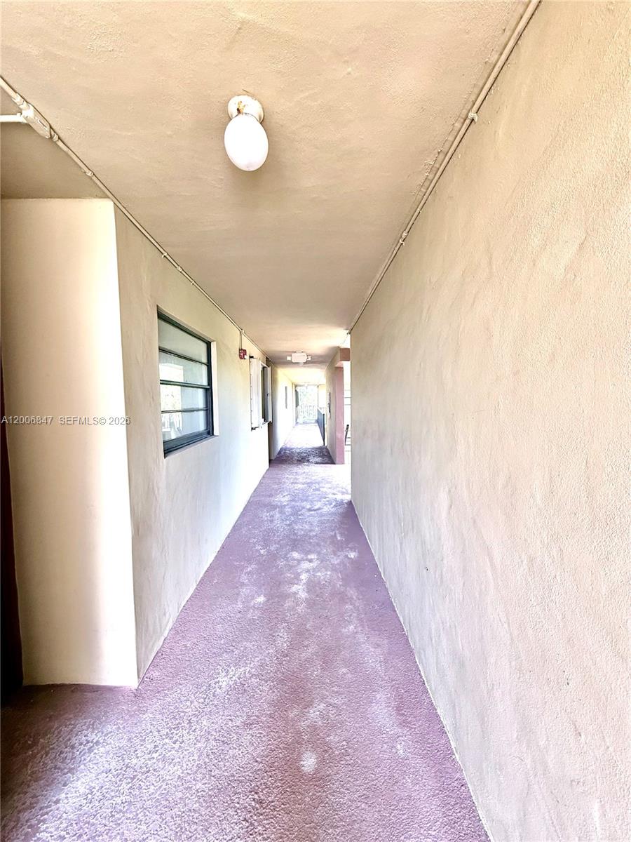 10835 Southwest 112th Avenue, Unit 306 Miami, FL 33176 - Photo 3 of 19 a view of a hallway with wooden floor and a bathroom