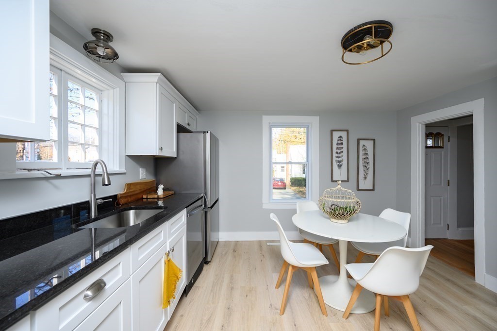 9 Bank Street Abington, MA 02351 - Photo 5 of 16 a kitchen with a table chairs stove and wooden floor