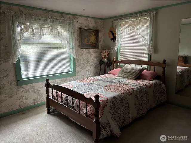 a bed sitting in a bedroom next to a window