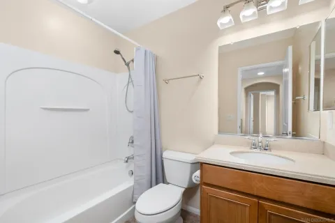 a bathroom with a granite countertop sink a toilet and shower