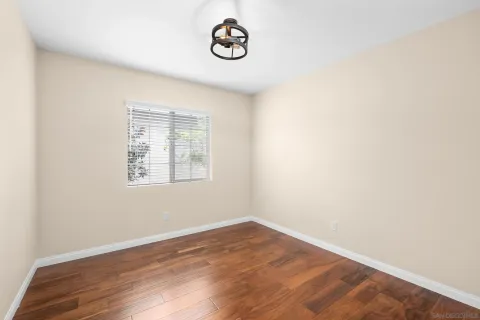 an empty room with wooden floor and window