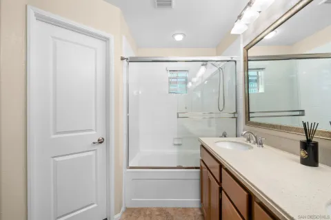 a bathroom with a shower sink and mirror