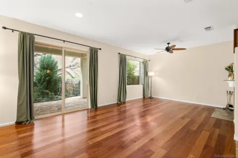 a view of a big room with wooden floor and windows