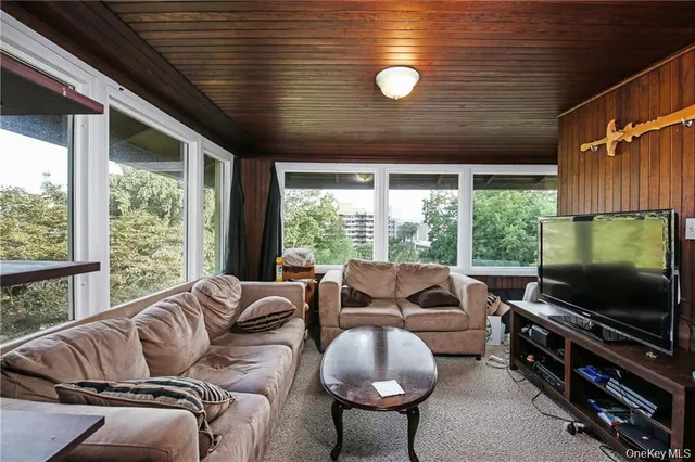 a living room with furniture tv and a large window