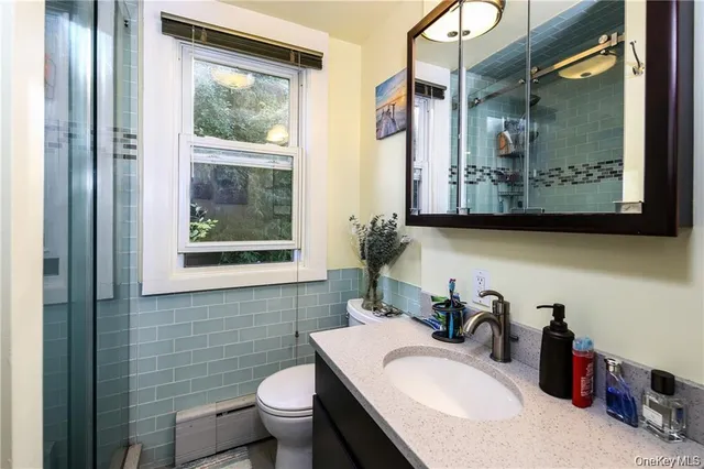 a bathroom with a granite countertop sink and a toilet