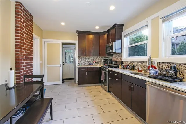 a large kitchen with stainless steel appliances kitchen island granite countertop a sink and cabinets
