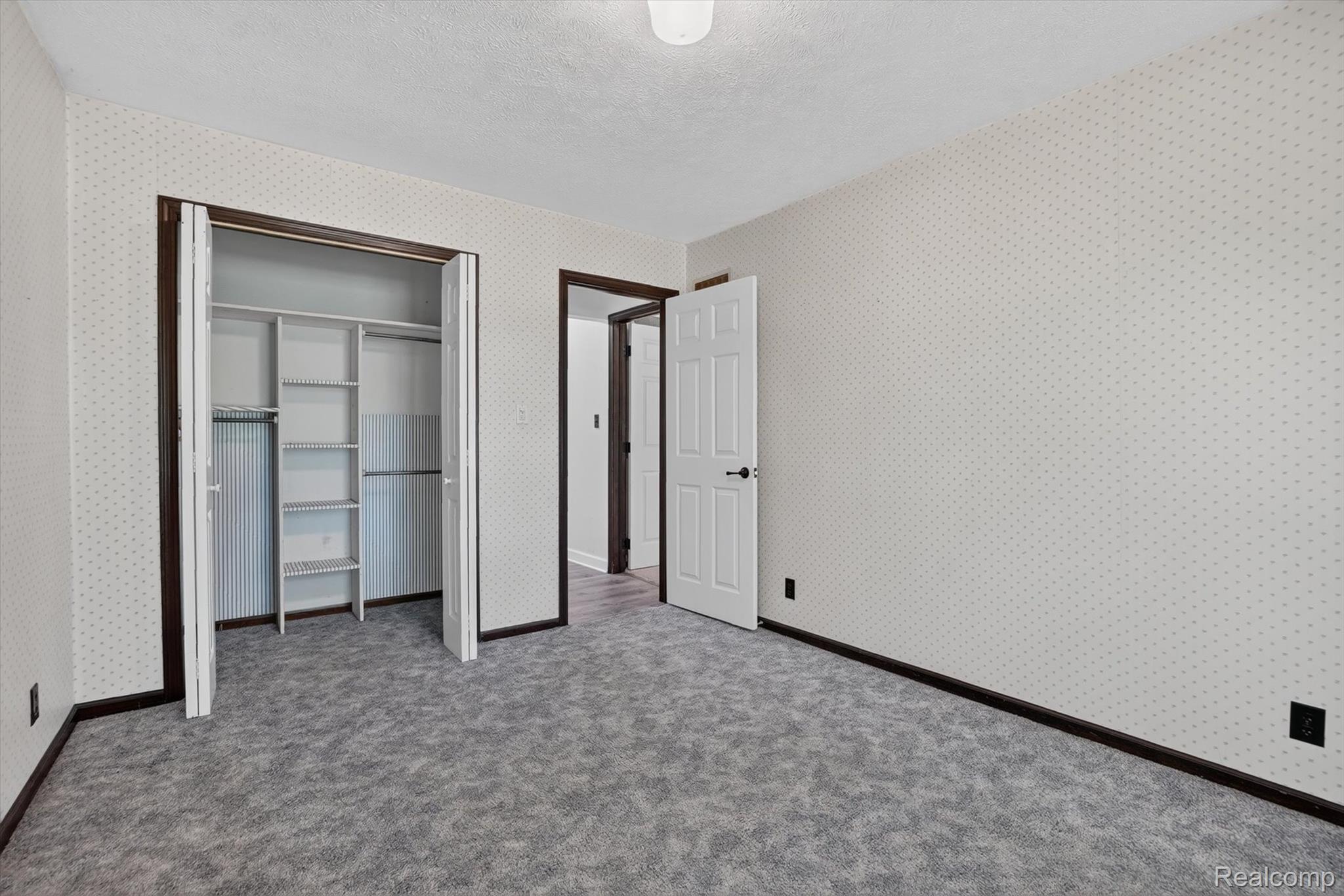 3760 Webberville Road North Williamston, MI 48895 - Photo 19 of 80 Room featuring light patterned wallpaper, dark trim, and gray carpeting