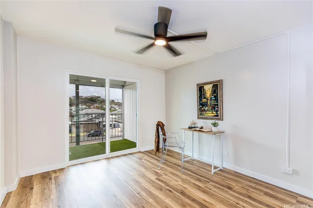a view of empty room with a window and wooden floor