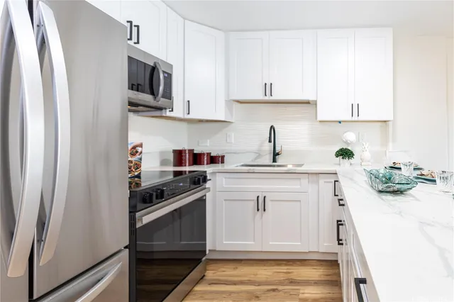 a kitchen with stainless steel appliances white cabinets and a sink