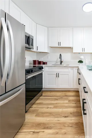 a kitchen with stainless steel appliances granite countertop a stove a sink and a refrigerator
