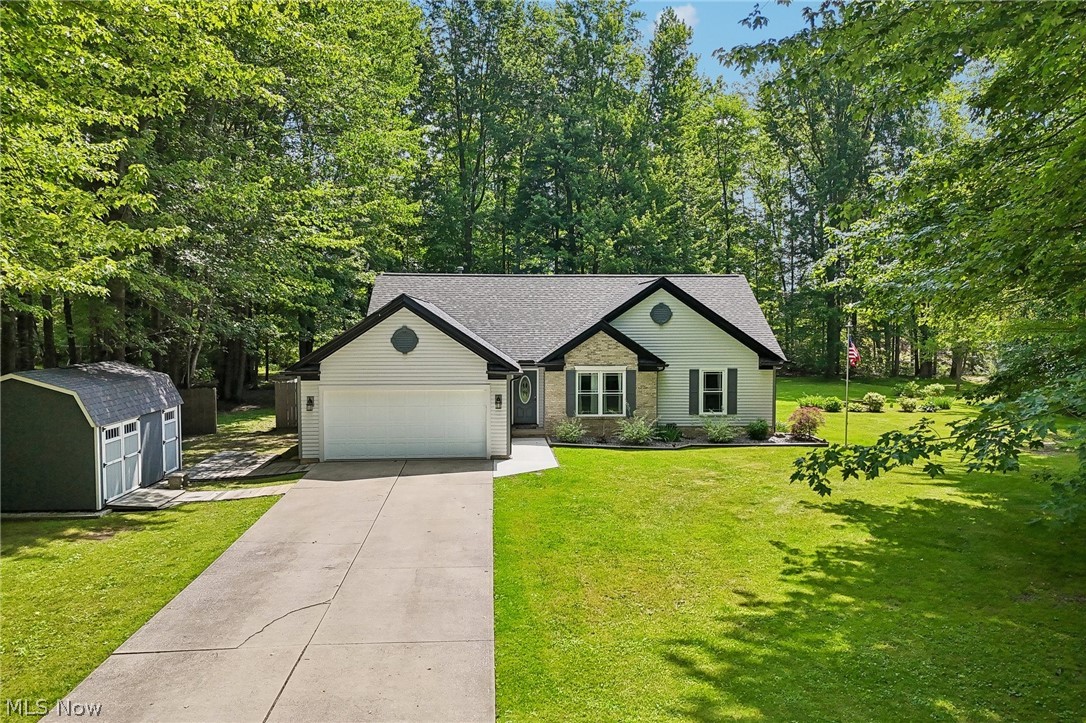 3213 Bates Road Madison, OH 44057 - Photo 2 of 45 Ranch-style residence featuring a two-car garage, concrete driveway, and stone accents