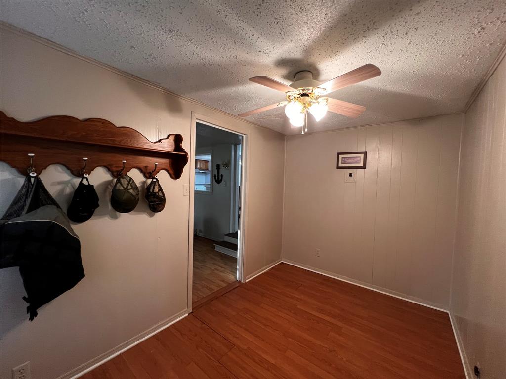 1036 Paradise Cove Road Pottsboro, TX 75076 - Photo 12 of 40 an empty room with wooden floor and ceiling fan
