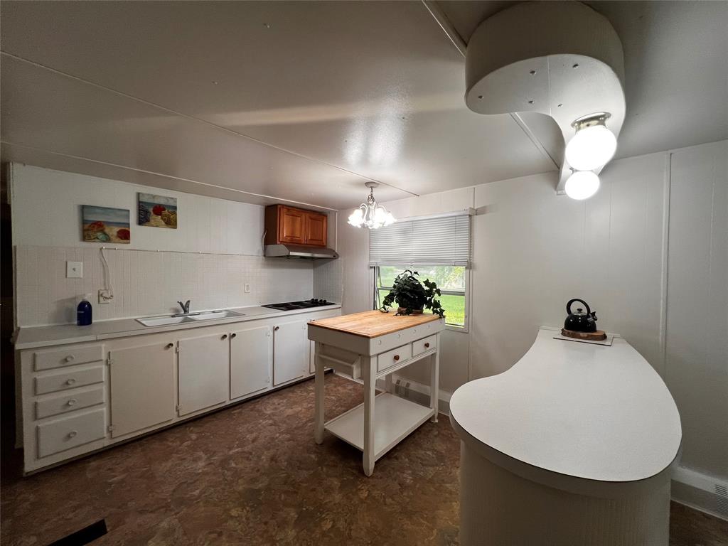 1036 Paradise Cove Road Pottsboro, TX 75076 - Photo 2 of 40 a kitchen with a sink a window and chairs