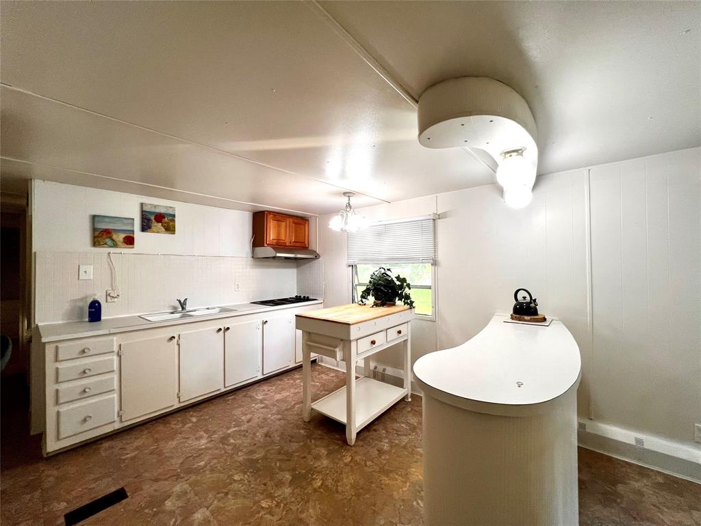 1036 Paradise Cove Road Pottsboro, TX 75076 - Photo 8 of 40 a kitchen with sink a white cabinets and chairs