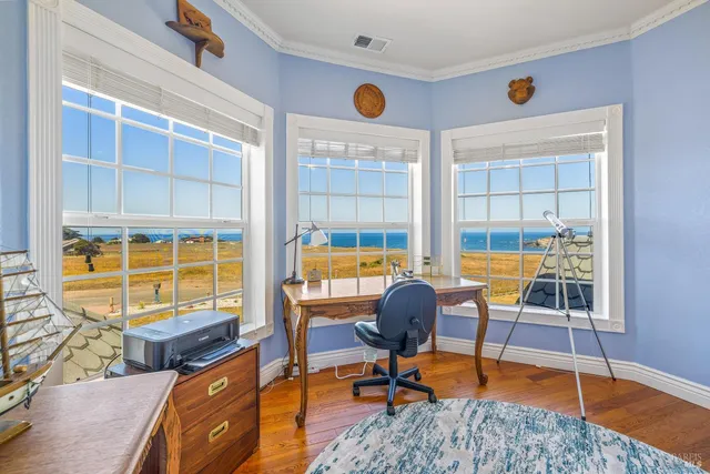a view of a workspace with furniture and a window