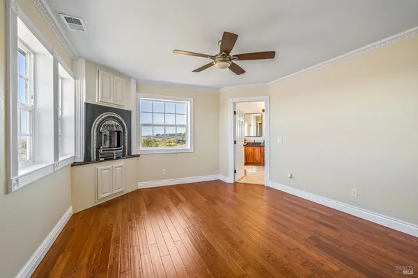 a view of empty room with a kitchen and wooden floor