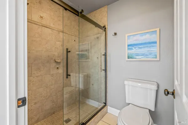 a bathroom with a toilet and a shower