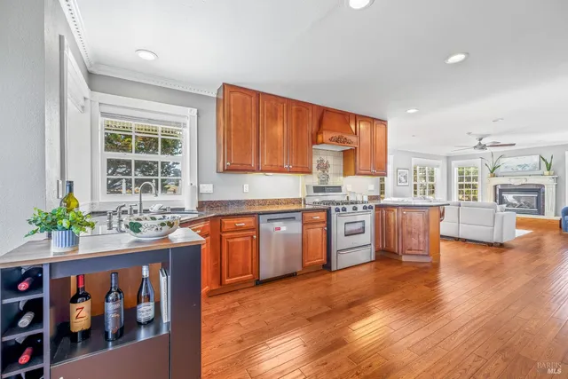 a open kitchen with stainless steel appliances granite countertop a stove a sink and a refrigerator