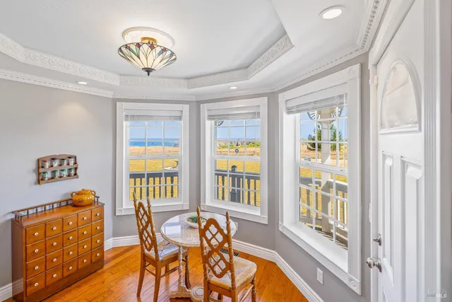 a view of a dining room with furniture a chandelier and wooden floor