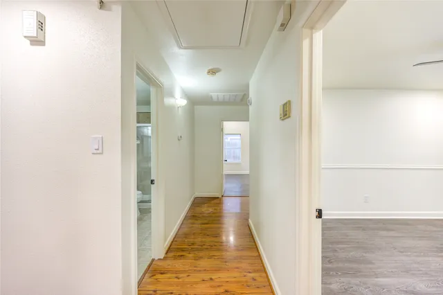 a view of a hallway with wooden floor