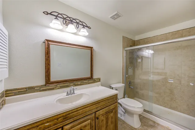 a bathroom with a sink a toilet a mirror and shower