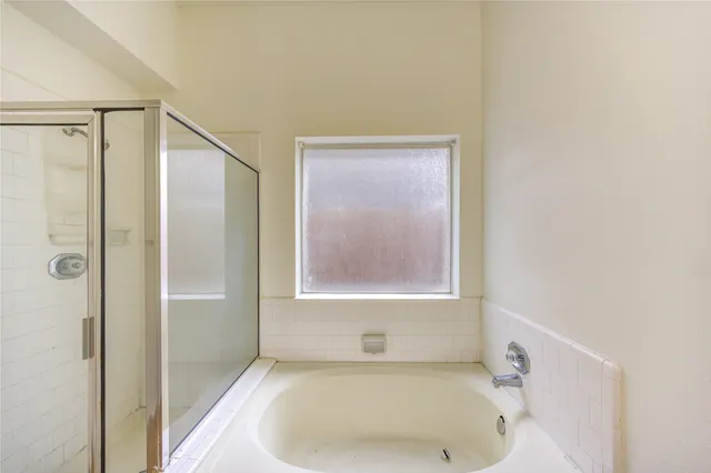 a bathroom with a tub and shower