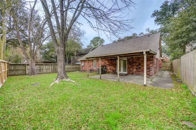 a view of a house with backyard and a tree