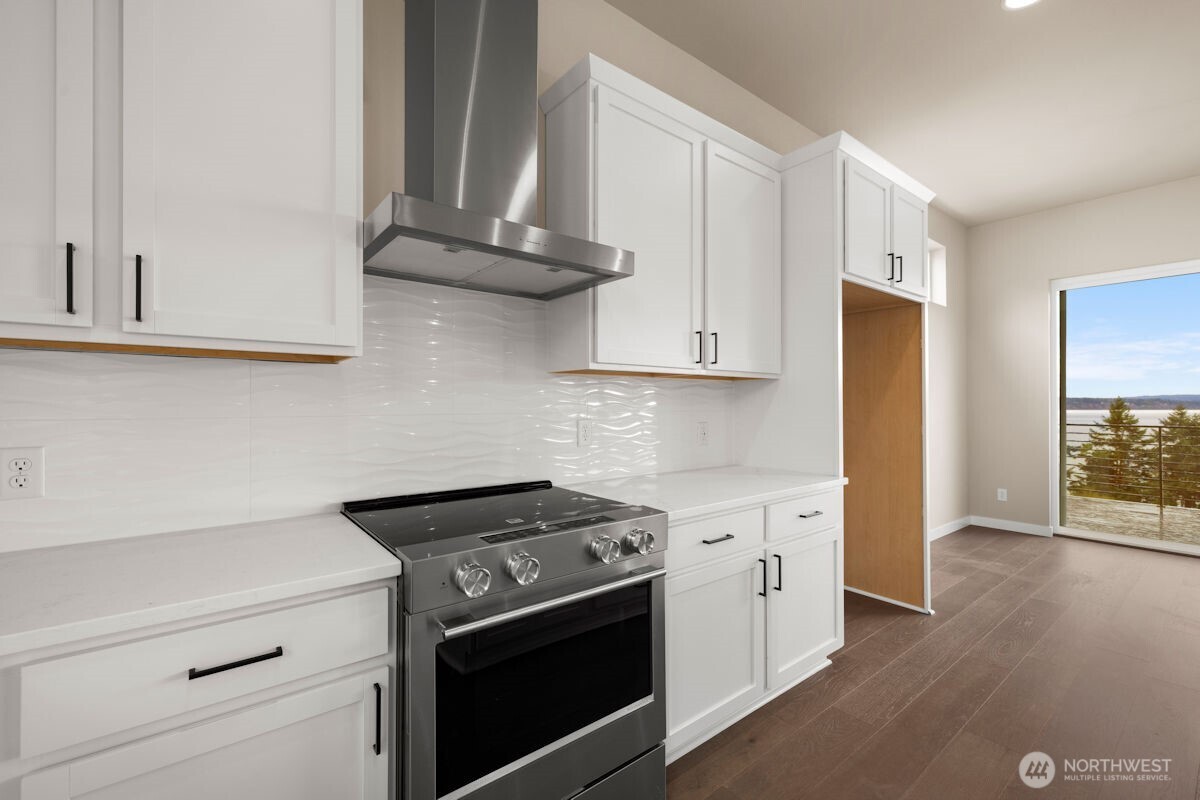 2216 Cleven Park Road Camano Island, WA 98282 - Photo 14 of 38 a kitchen with stainless steel appliances granite countertop white cabinets and a stove top oven