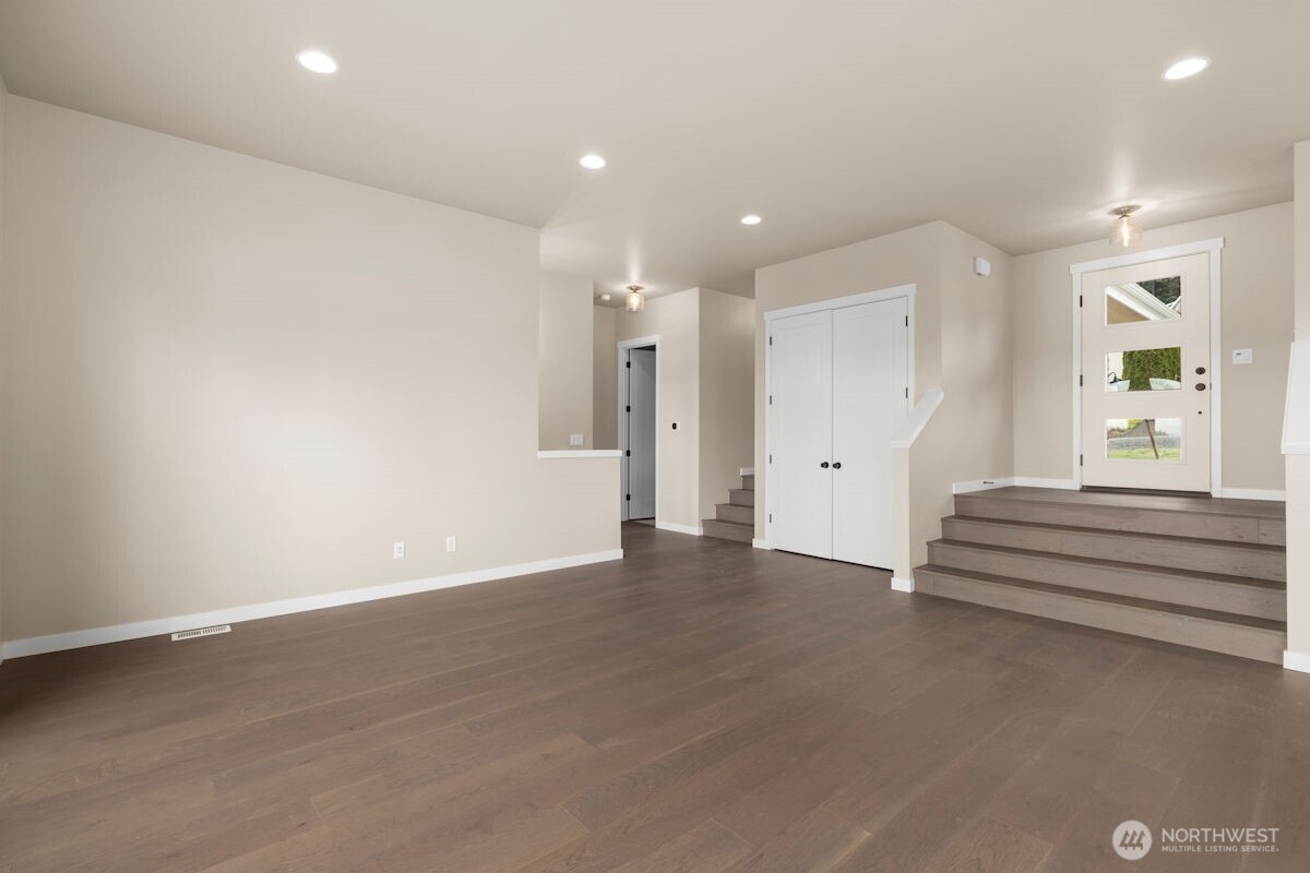 2216 Cleven Park Road Camano Island, WA 98282 - Photo 16 of 38 a view of an empty room with wooden floor and windows