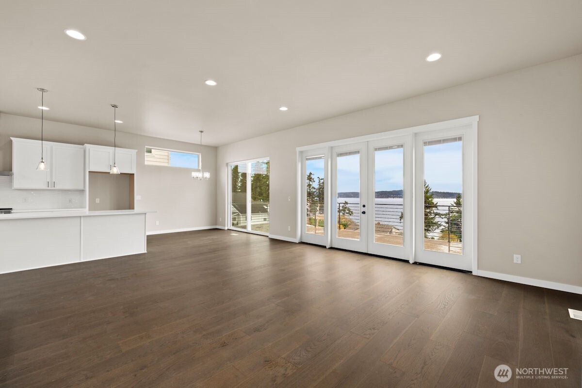 2216 Cleven Park Road Camano Island, WA 98282 - Photo 21 of 38 a view of an empty room with a floor to ceiling window and wooden floor