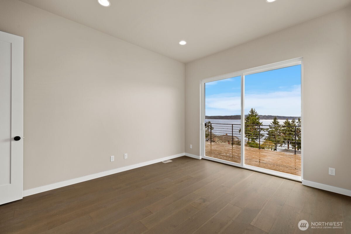 2216 Cleven Park Road Camano Island, WA 98282 - Photo 23 of 38 an empty room with sliding door and wooden floor