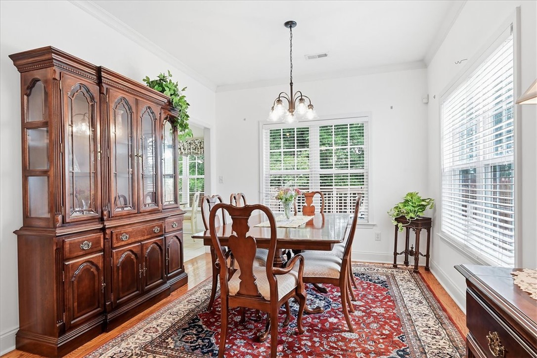 112 Elliott Circle Anderson, SC 29621 - Photo 9 of 35 Hardwood floors and bright windows illuminate this inviting dining space, ready for memorable meals.
