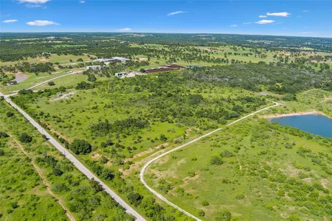 an aerial view of residential houses with outdoor space and trees