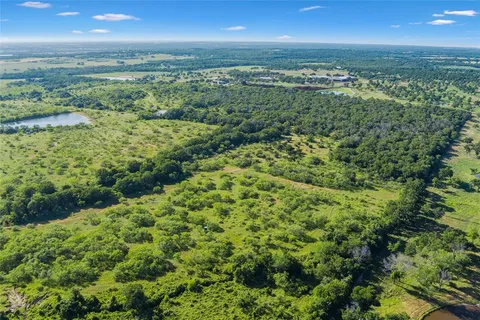 an aerial view of residential houses with outdoor space and trees