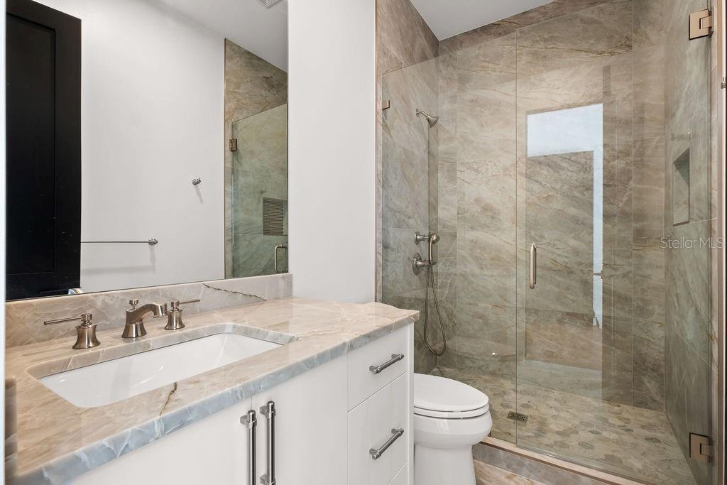 9725 Chestnut Ridge Drive Windermere, FL 34786 - Photo 45 of 61 a bathroom with a granite countertop sink a toilet a mirror and shower