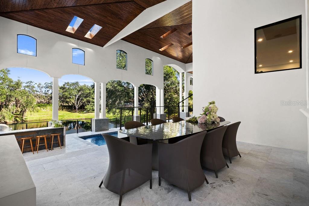 9725 Chestnut Ridge Drive Windermere, FL 34786 - Photo 54 of 61 a dining room with furniture a large window and palm tree