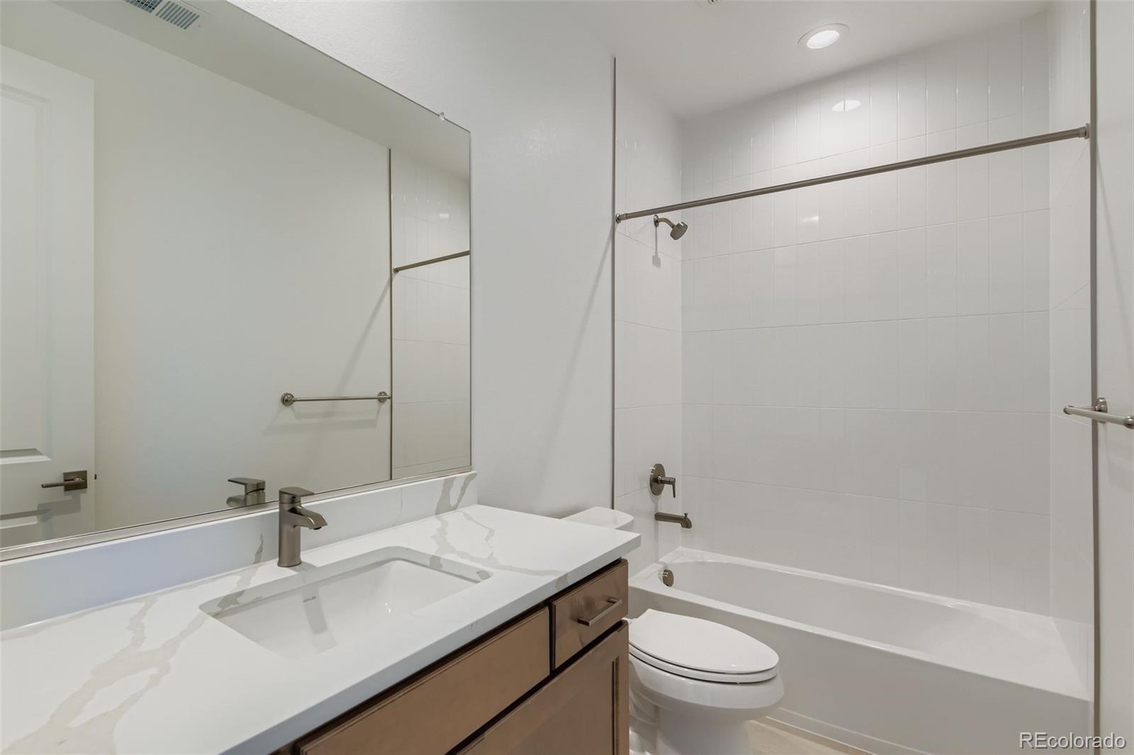 622 Saddle Drive Erie, CO 80516 - Photo 11 of 25 a bathroom with a granite countertop sink toilet and shower