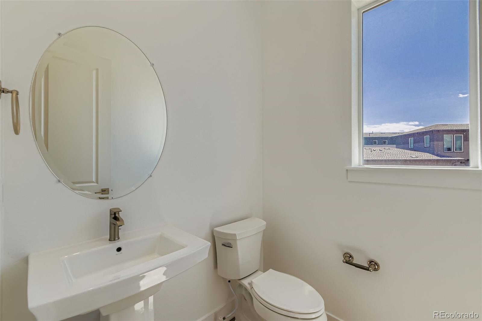 622 Saddle Drive Erie, CO 80516 - Photo 3 of 25 a white toilet sitting next to a bathroom sink